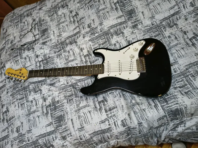 Guitarra eléctrica negra con amplificador - 1