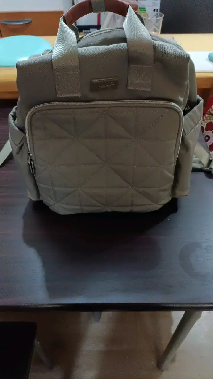Mochila pañalera gris con múltiples compartimentos