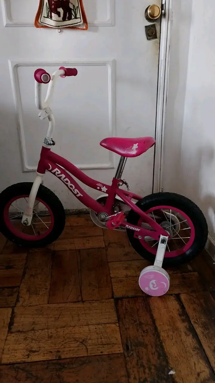 Bicicleta infantil rosa con ruedas de entrenamiento