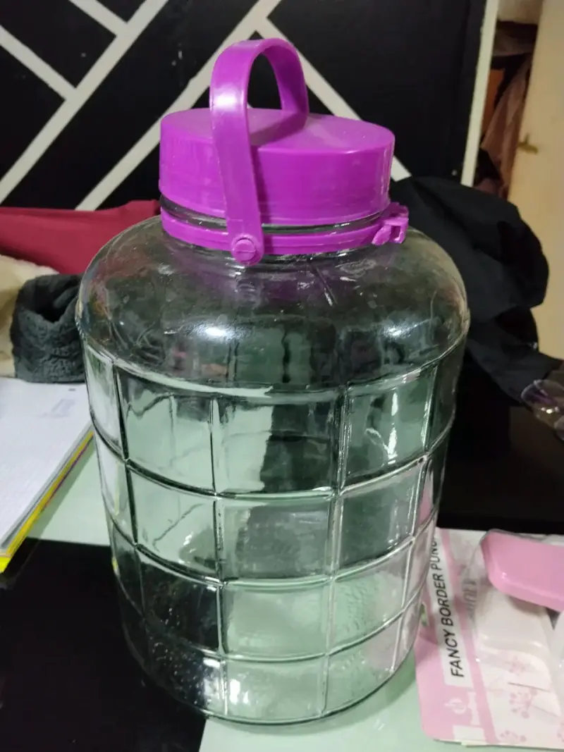 Botella de vidrio con tapa morada