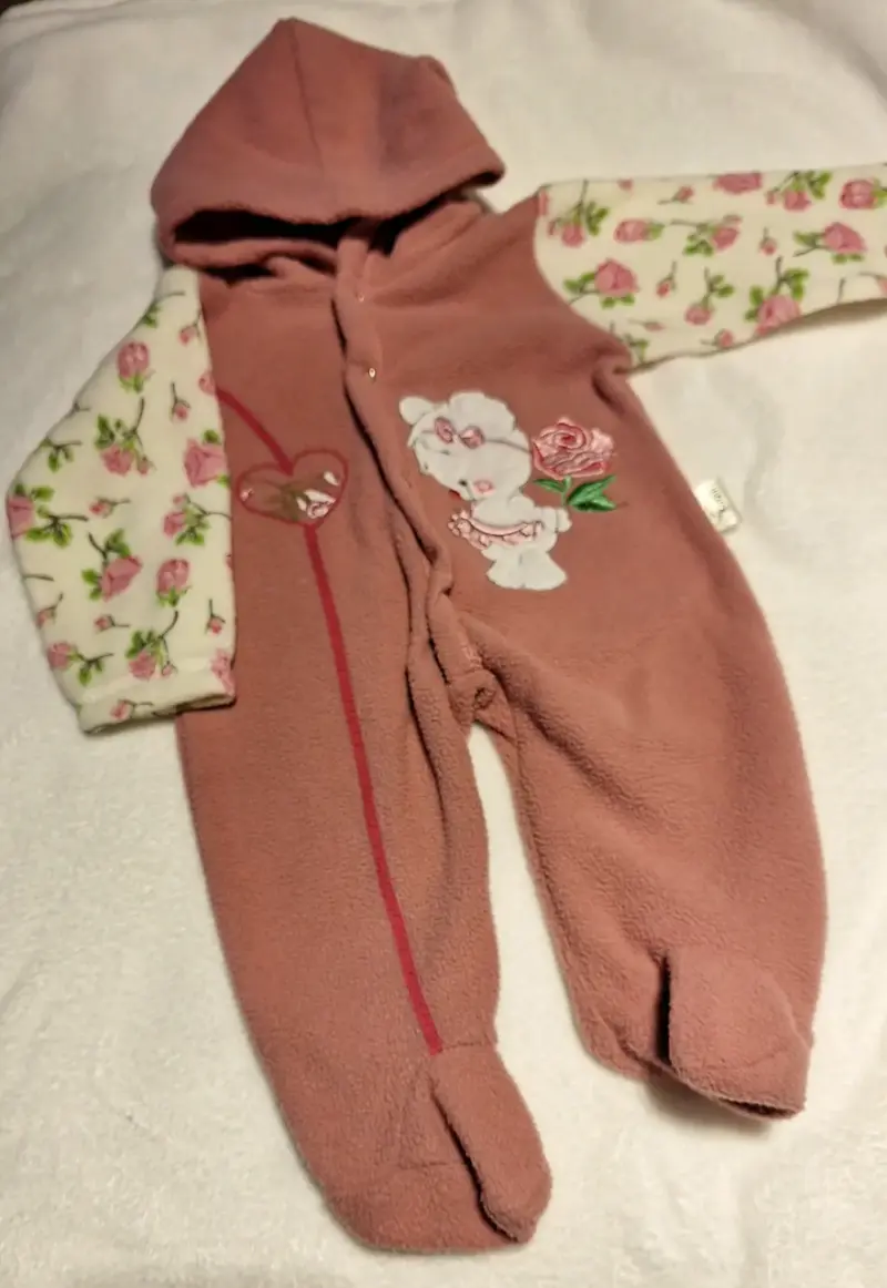 Enterito de bebé con diseño floral y capucha.