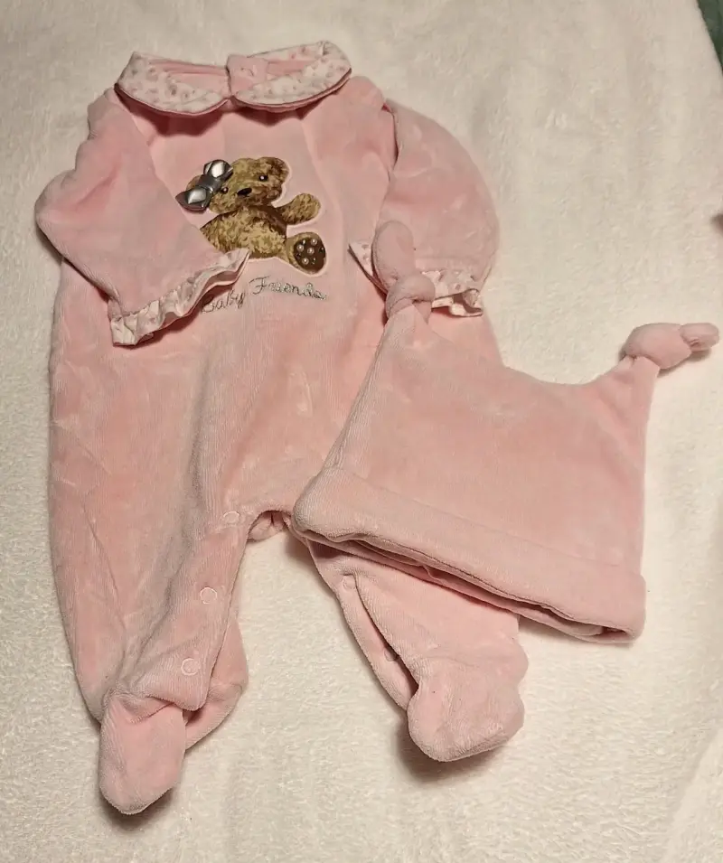 Pijama de bebé rosado con gorro y diseño de oso.