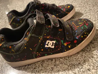 Zapatillas DC negras con diseño de salpicaduras - miniatura 1