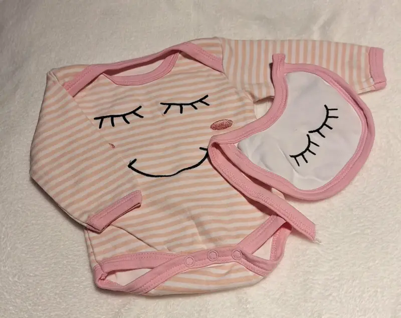 Conjunto de body y babero para bebé rosado. T-Rn