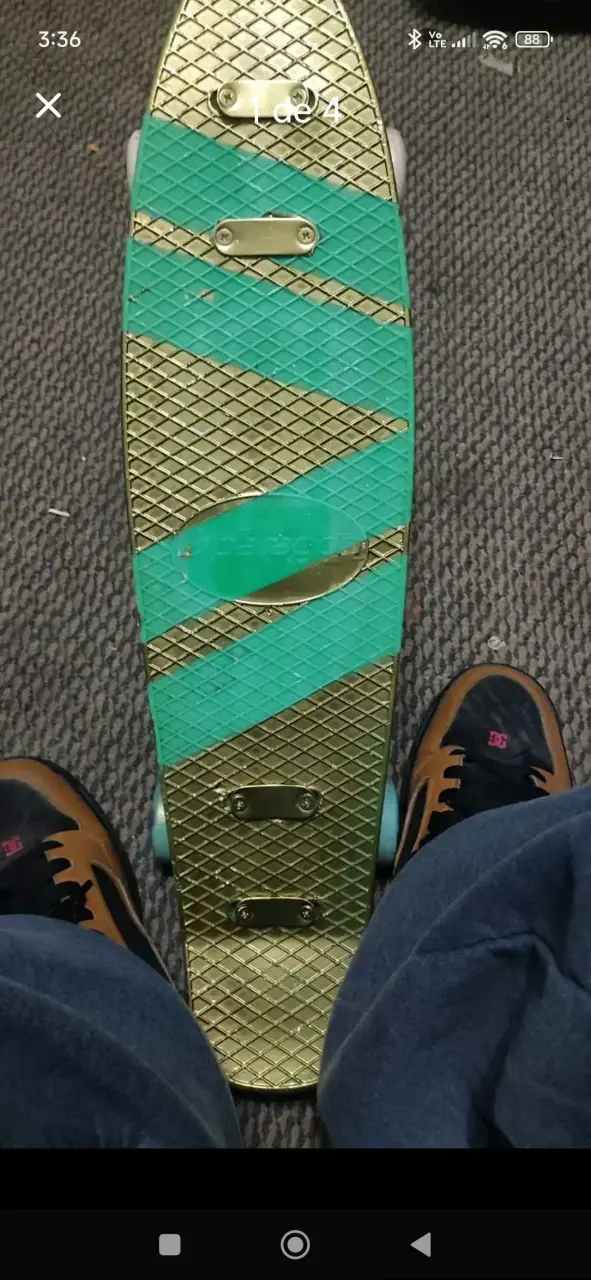 Skateboard verde y dorado con ruedas azules