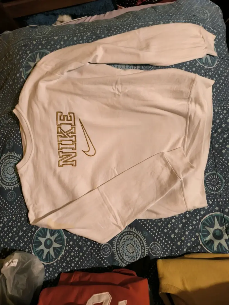 Polerón blanco Nike con logo dorado