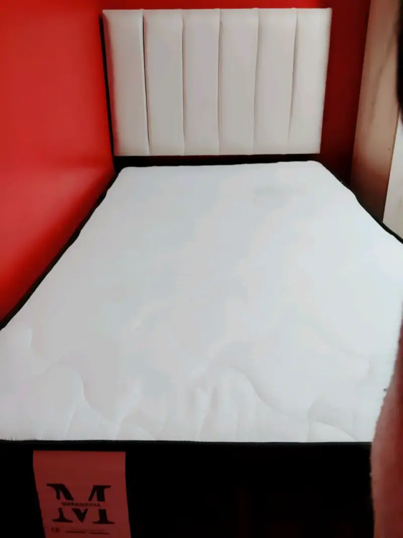 Cama con colchón y respaldo blanco