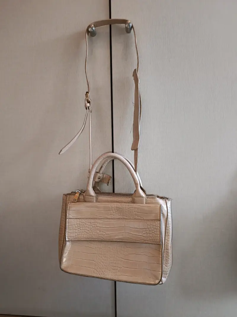 Cartera de mano beige con textura de cocodrilo