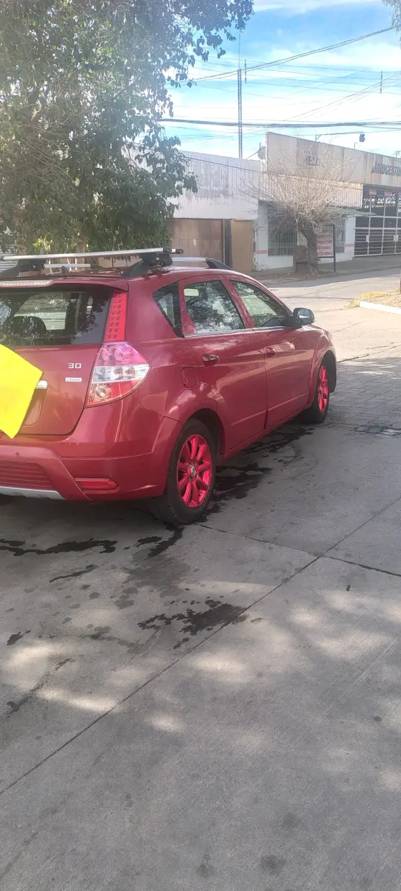 Auto hatchback rojo con llantas personalizadas - 1