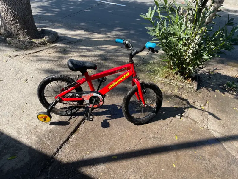 Bicicleta infantil roja con ruedas de entrenamiento