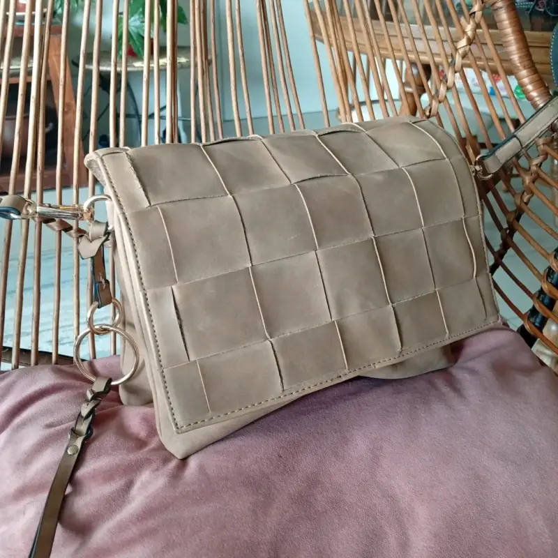 Cartera de cuerina beige con diseño trenzado