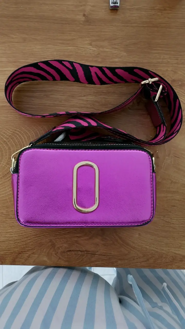 Cartera cruzada fucsia con correa estampada