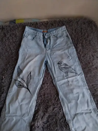 Jeans de mezclilla con diseño de hojas y pájaro - miniatura 1