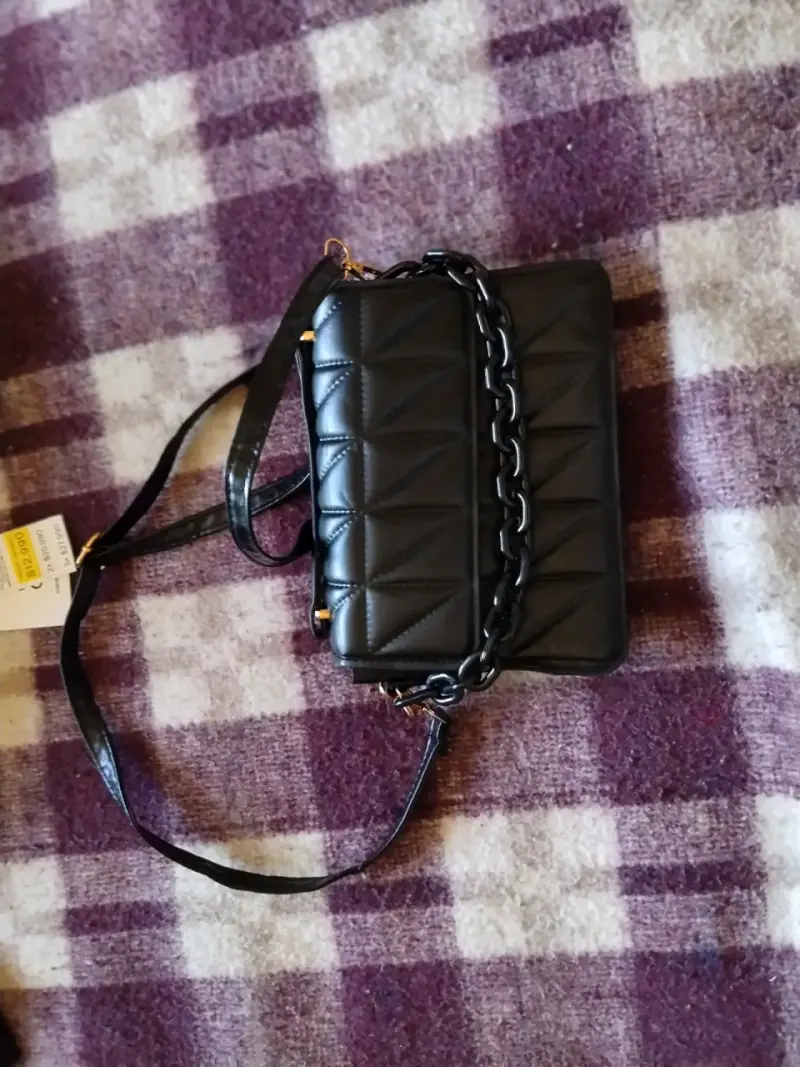 Cartera negra con diseño acolchado y cadena