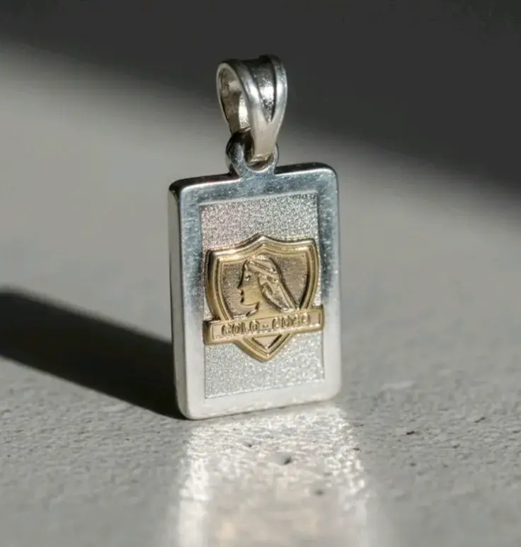 Colgante de plata y oro con diseño de escudo