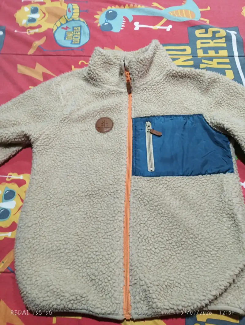 Chaqueta polar beige con bolsillo azul para niño