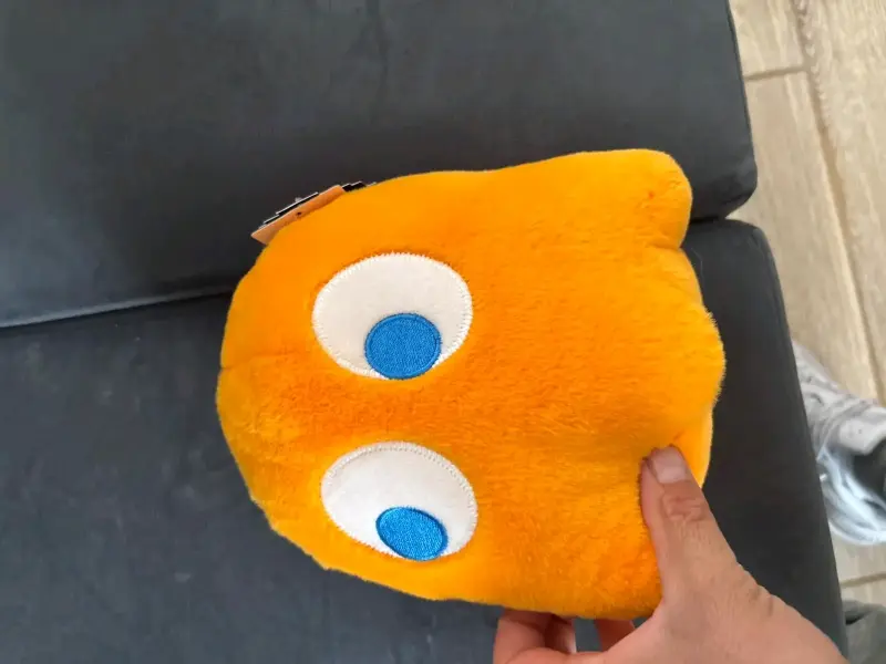 Cojín de peluche amarillo con ojos grandes