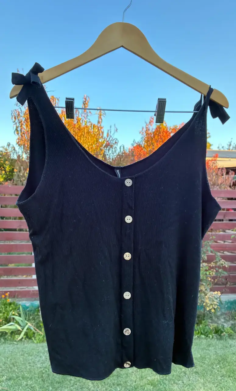 Blusa negra con botones y lazos en los hombros - 1