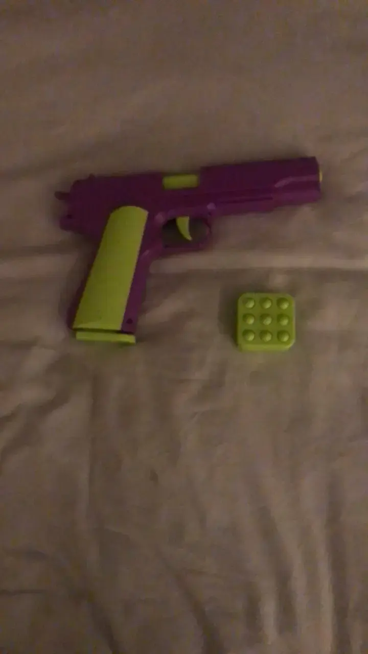 Pistola de juguete morada y verde con accesorios