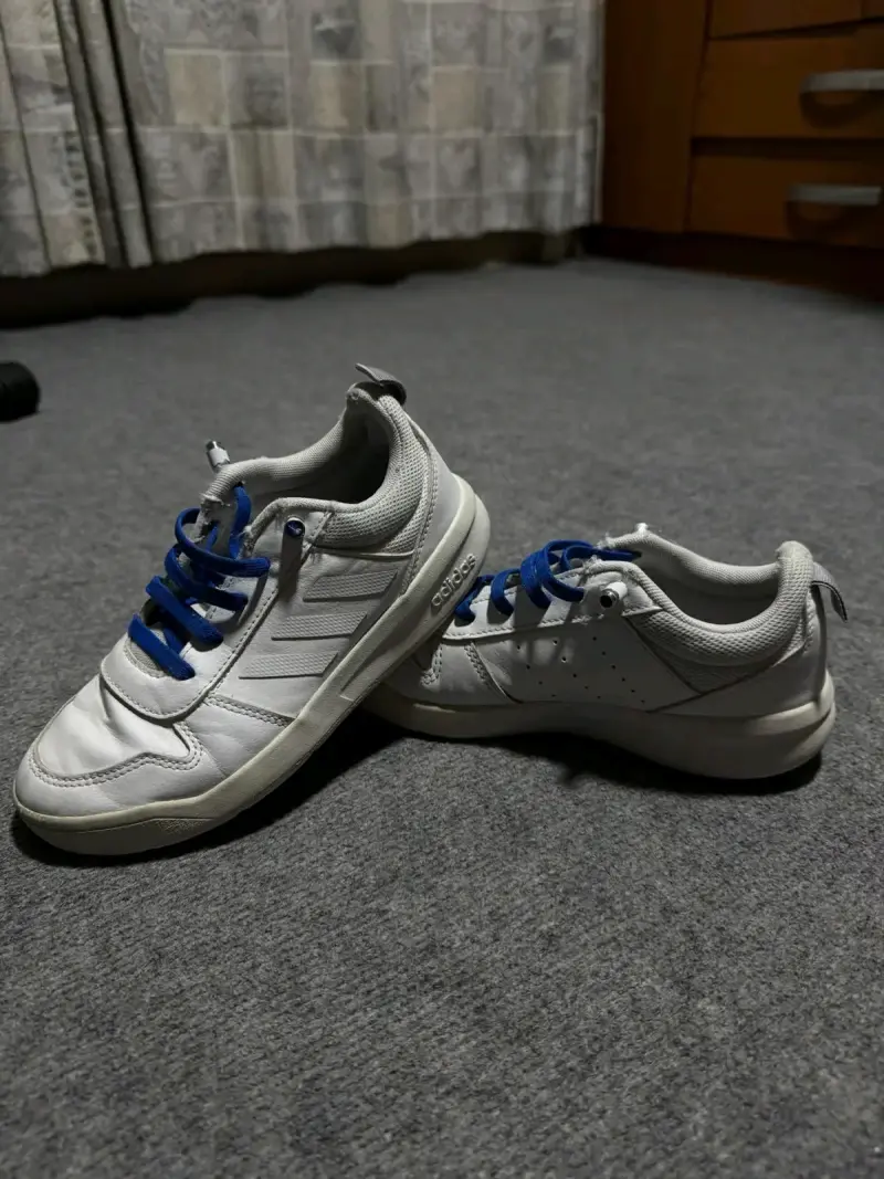Zapatillas deportivas blancas con cordones azules