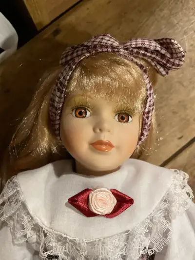 Muñeca de porcelana con vestido a cuadros - miniatura 1