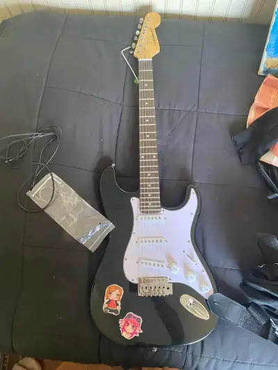 Guitarra eléctrica negra con stickers - miniatura 1