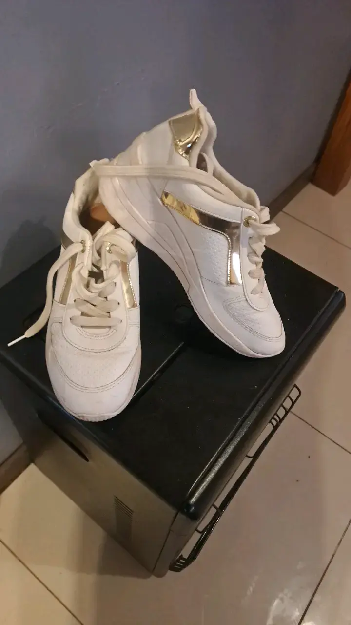 Zapatillas deportivas blancas con detalles dorados