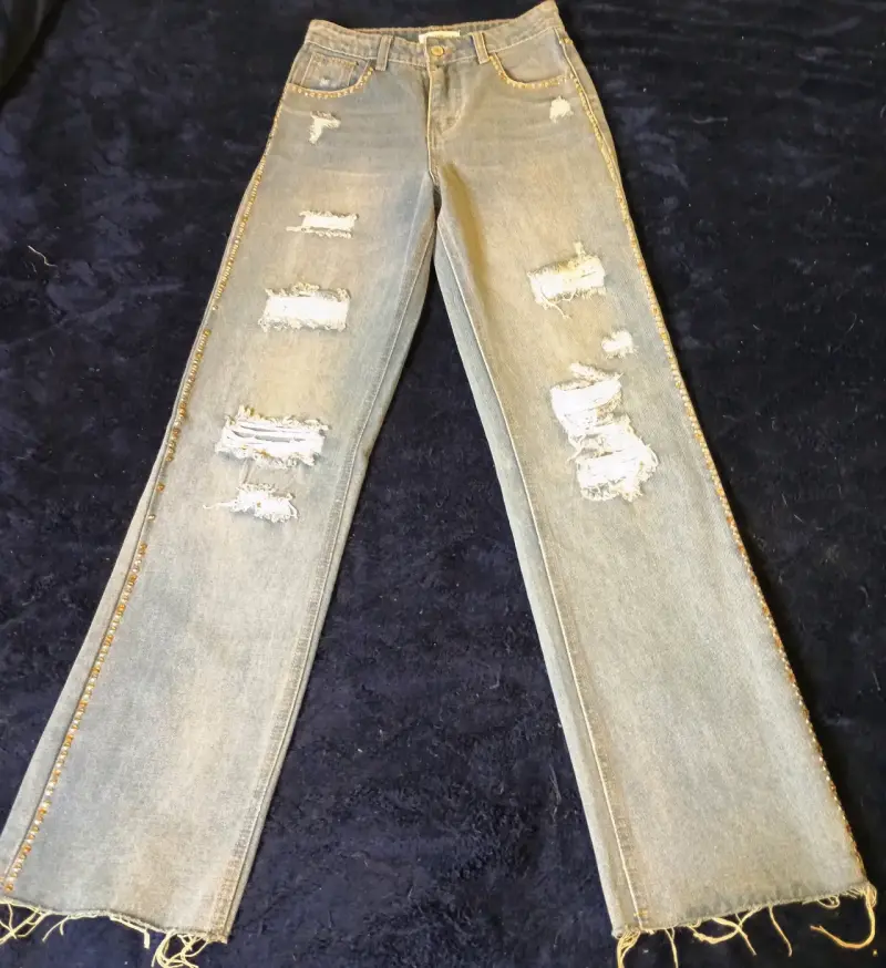 Jeans desgastados con detalles de tachas