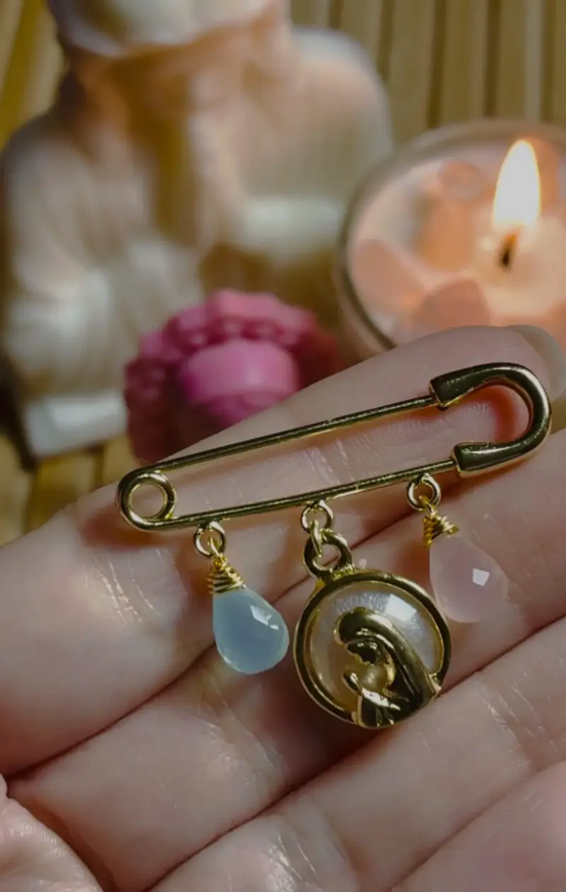 Broche de seguridad dorado con dijes religiosos