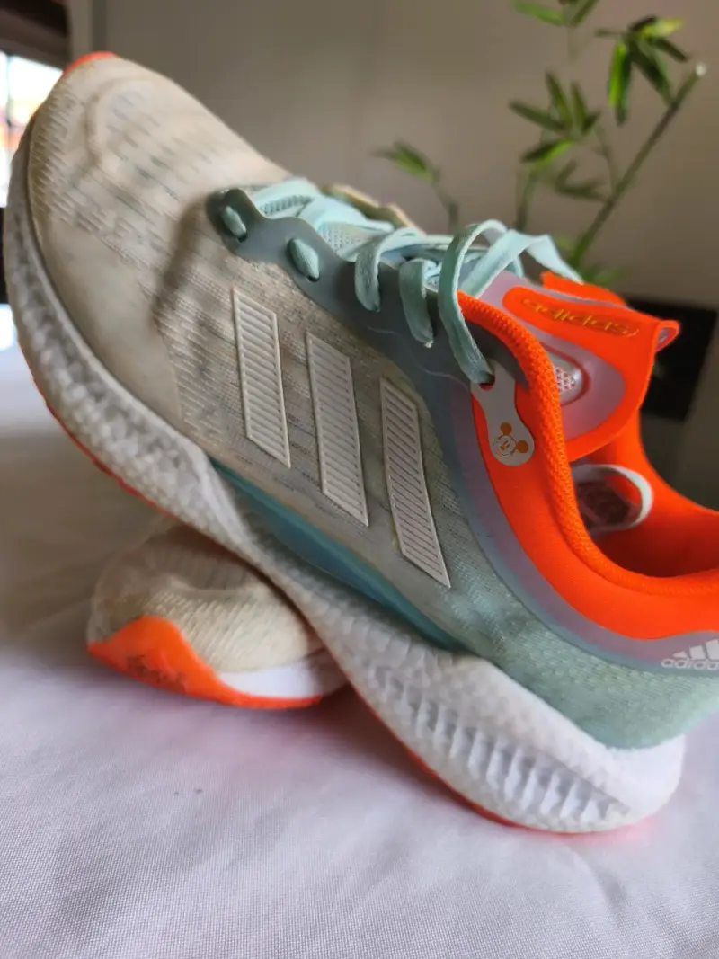Zapatillas deportivas Adidas con detalles naranjas