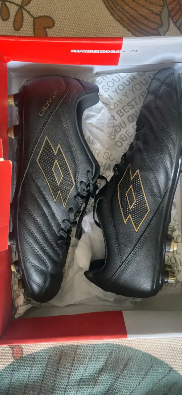 Botines de fútbol negros con diseño dorado