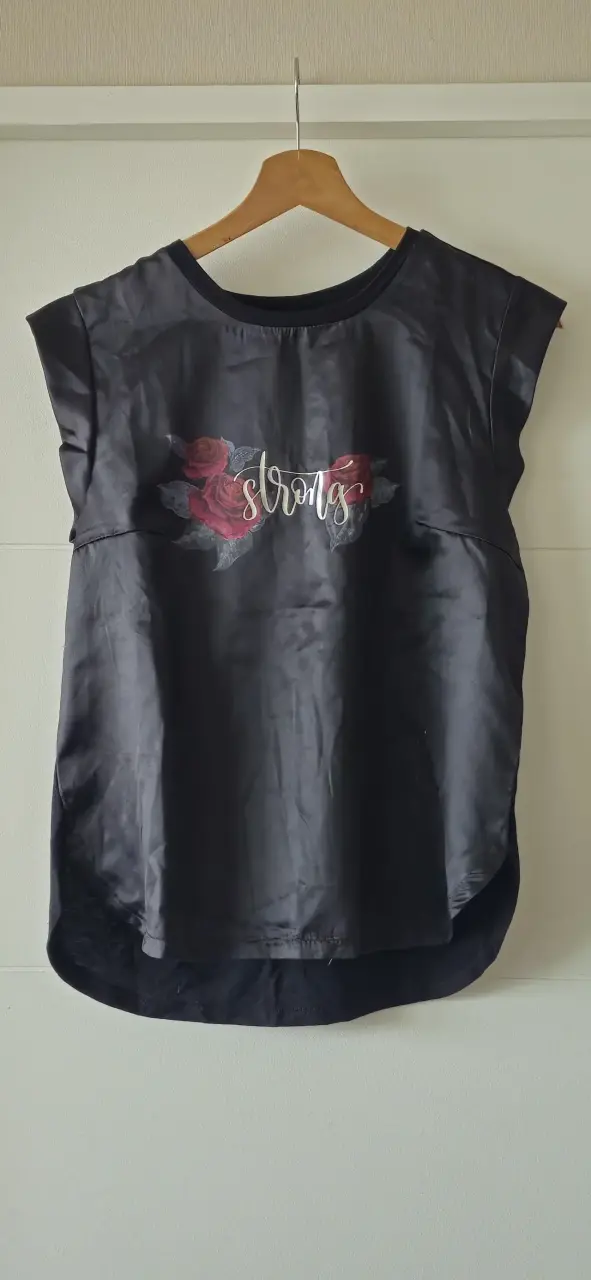 Polera negra con diseño floral y texto 'Strong' - 1
