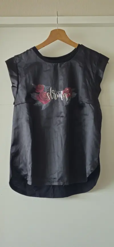 Polera negra con diseño floral y texto 'Strong' - miniatura 1