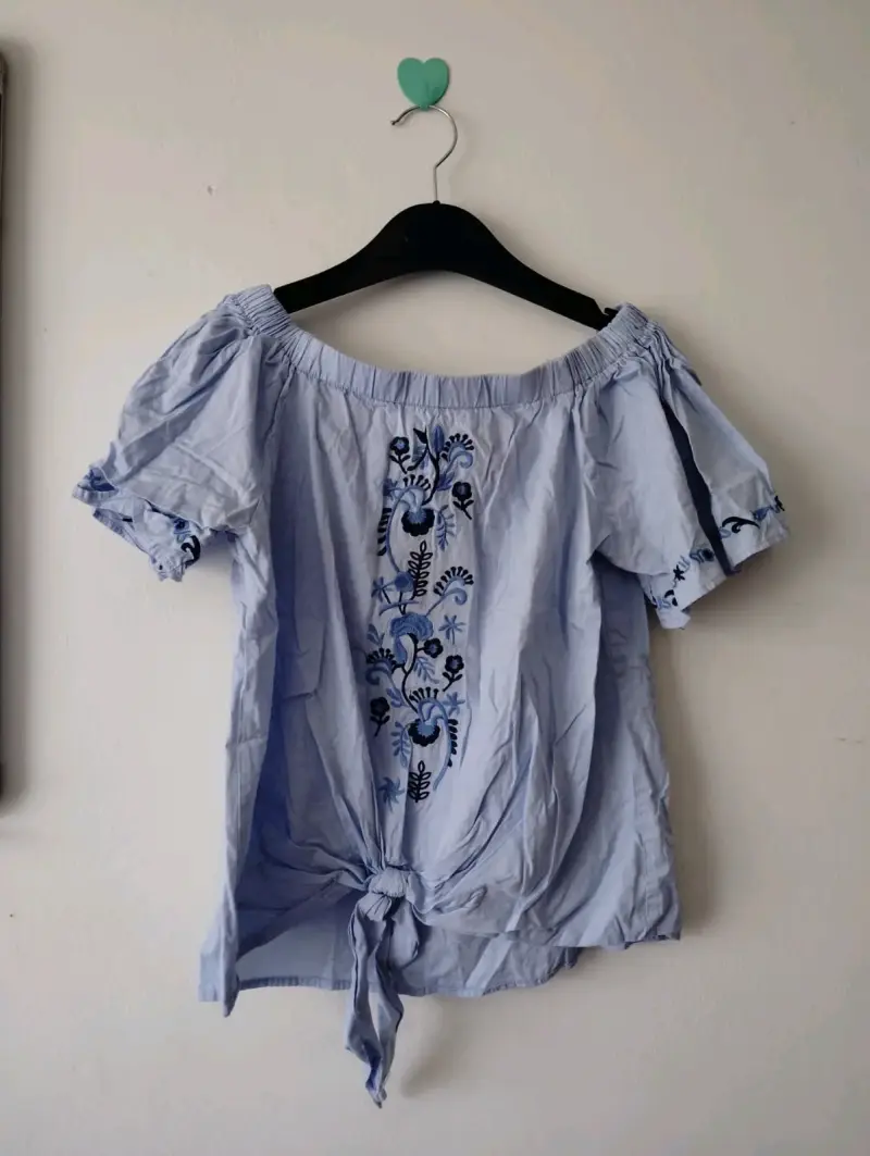 Blusa azul con bordado floral y hombros descubiertos - 1