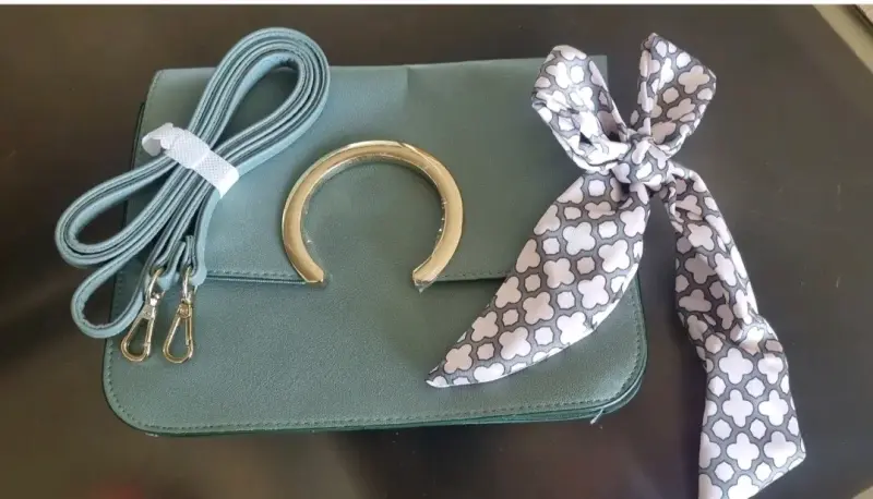 Cartera verde con correa y pañuelo decorativo