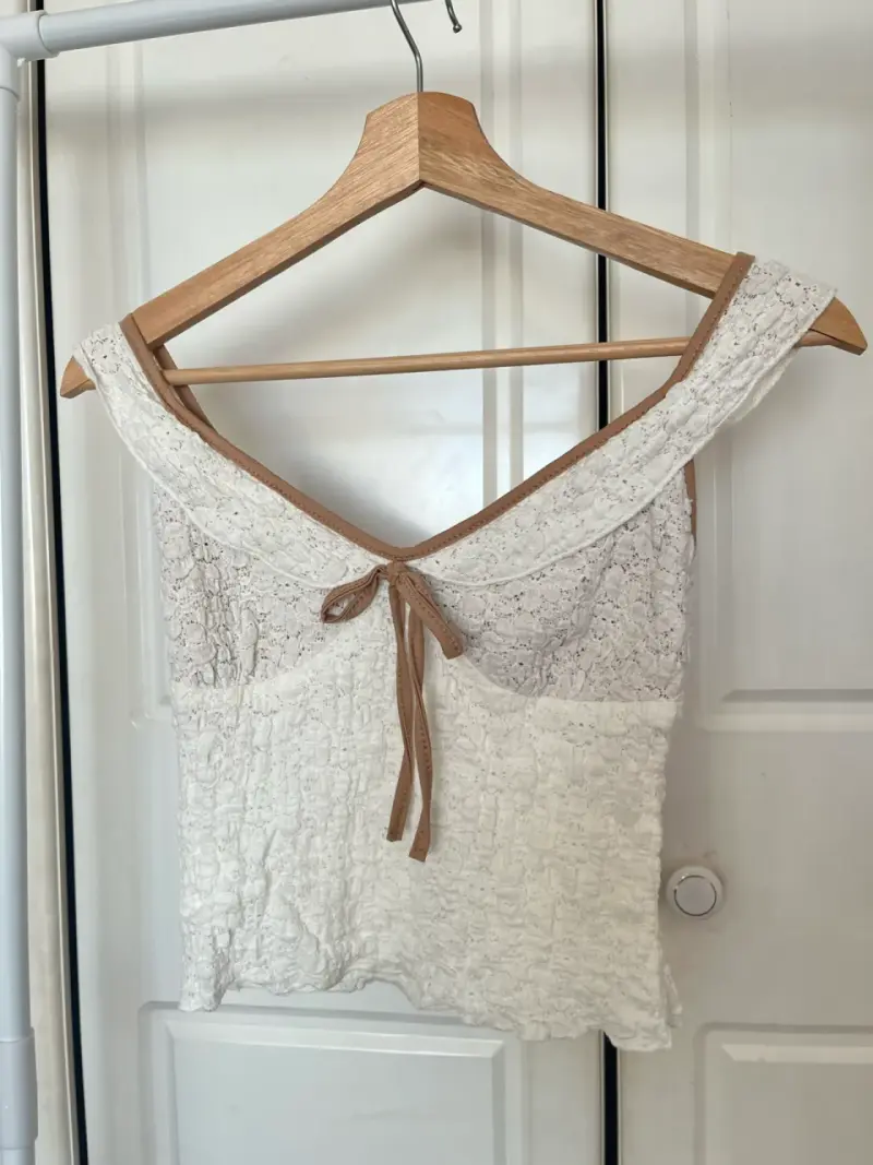 Top de encaje blanco con lazo decorativo
