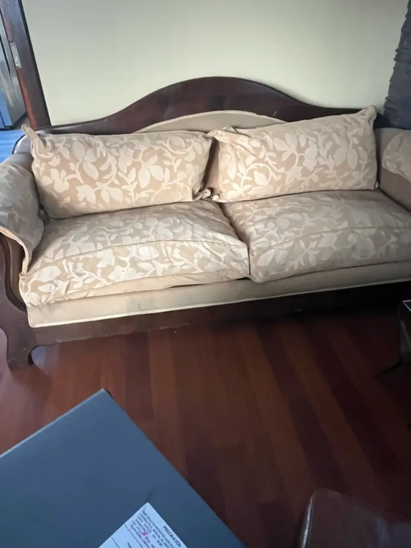 Sofá clásico de madera con cojines beige
