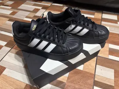Zapatillas deportivas negras con franjas blancas - miniatura 1