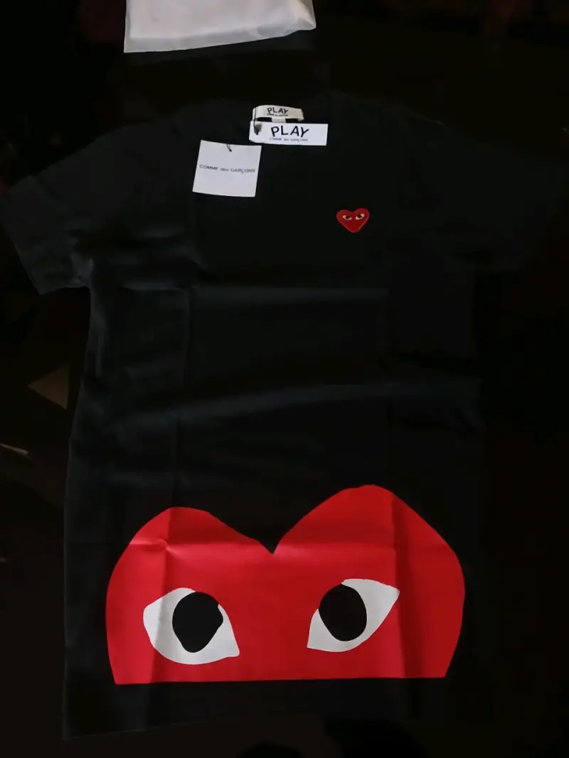 Polera negra cdg con diseño de corazón