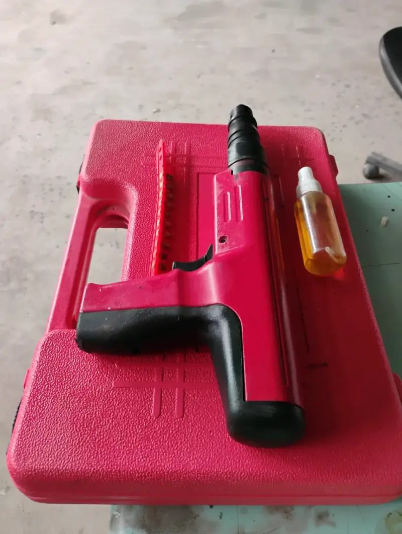 Pistola de clavos roja con maletín