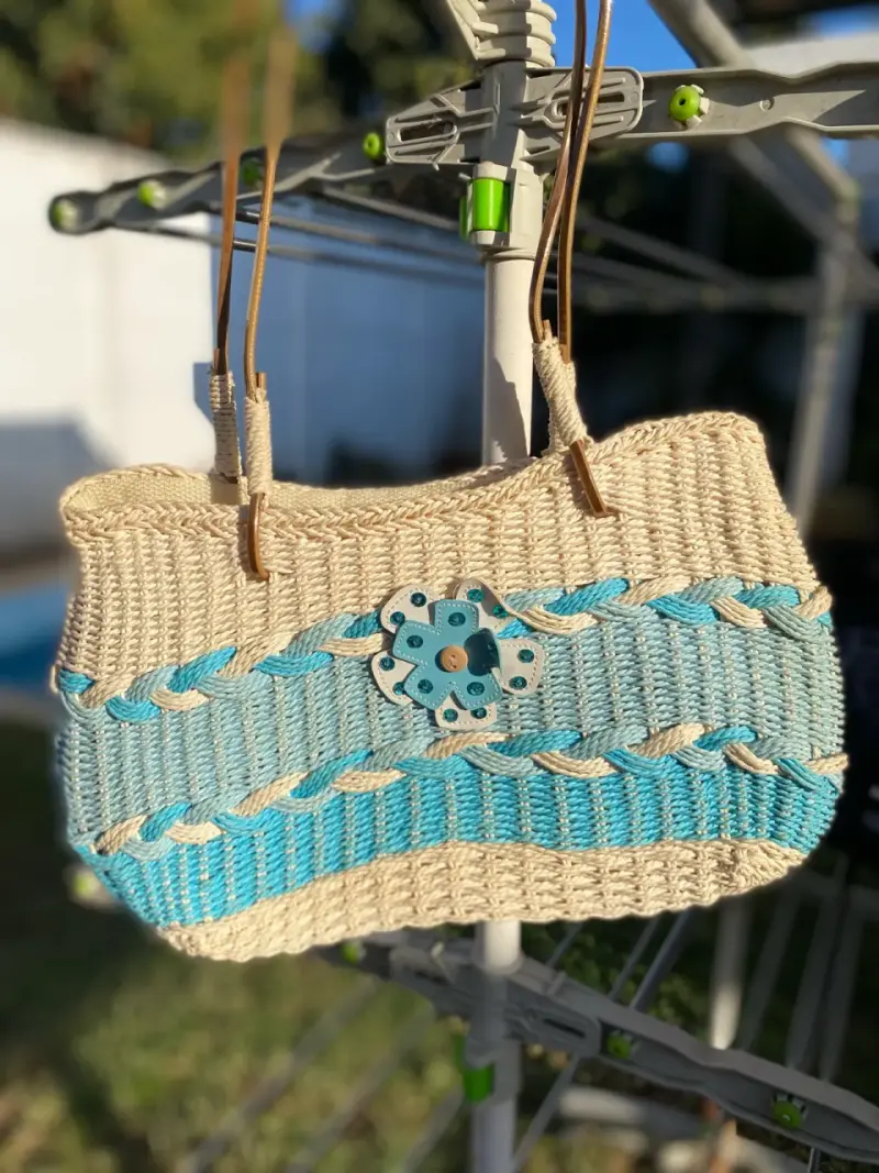 Bolso de paja tejido a mano con diseños celeste.
