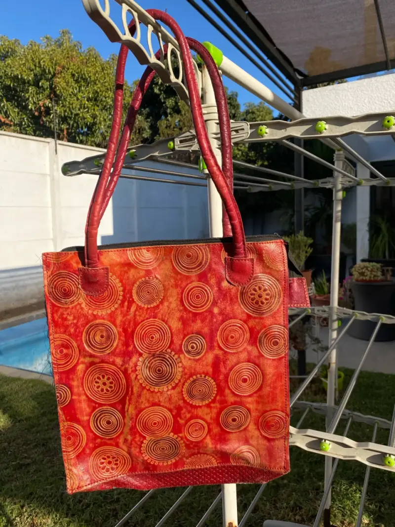 Bolso de cuero rojo con diseño circular