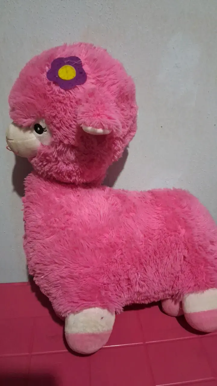 Peluche de alpaca rosa con flor decorativa