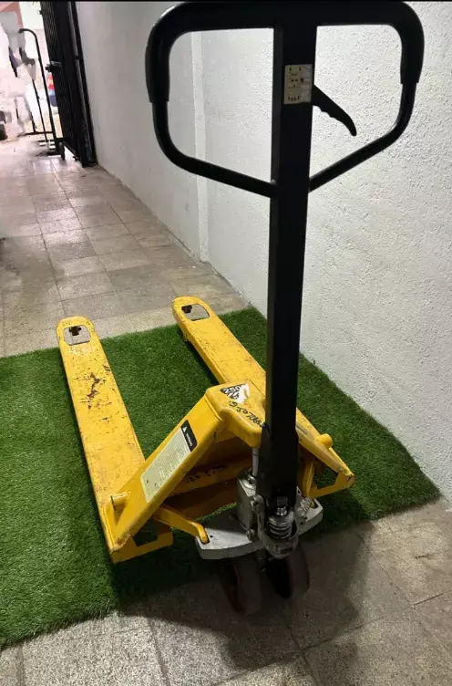 Transpaleta hidráulica amarilla en buen estado - 1