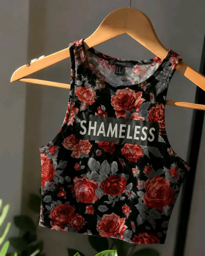 Crop top floral negro con texto 'Shameless'