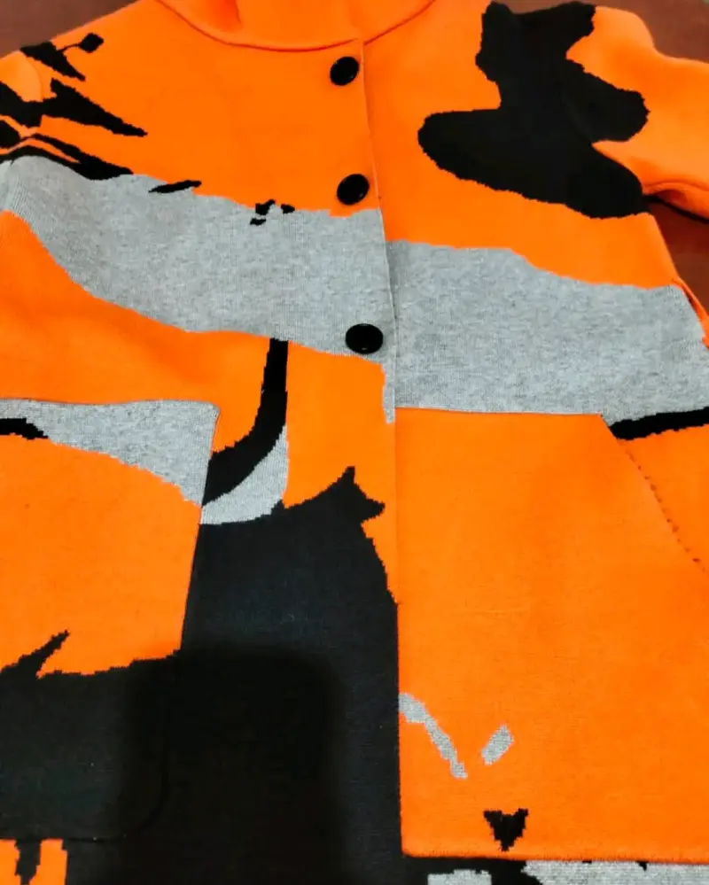 Abrigo de lana naranja y negro con diseño abstracto