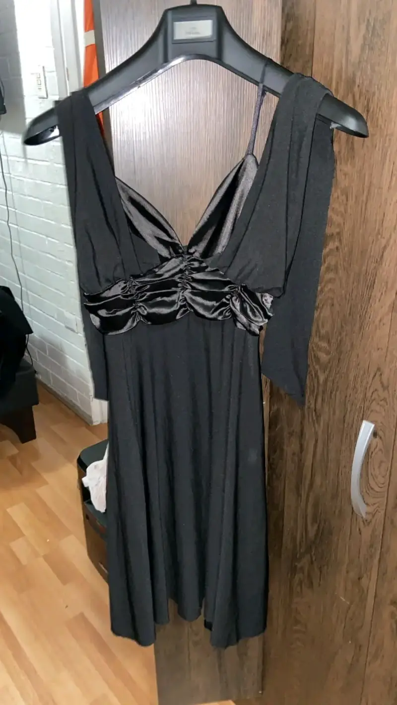 Vestido negro elegante con detalles satinados