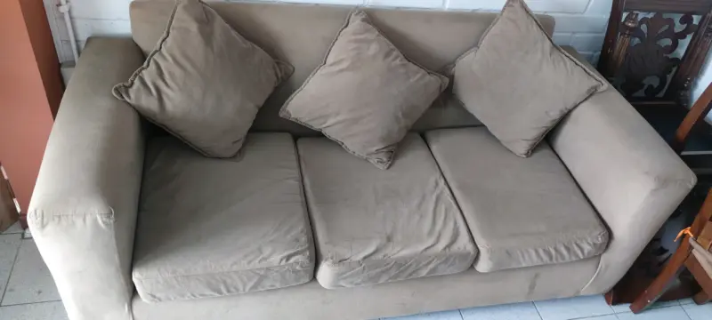 Sofá beige de tres plazas con cojines - 1