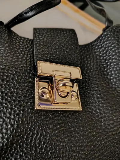 Bolso negro con broche metálico - miniatura 2