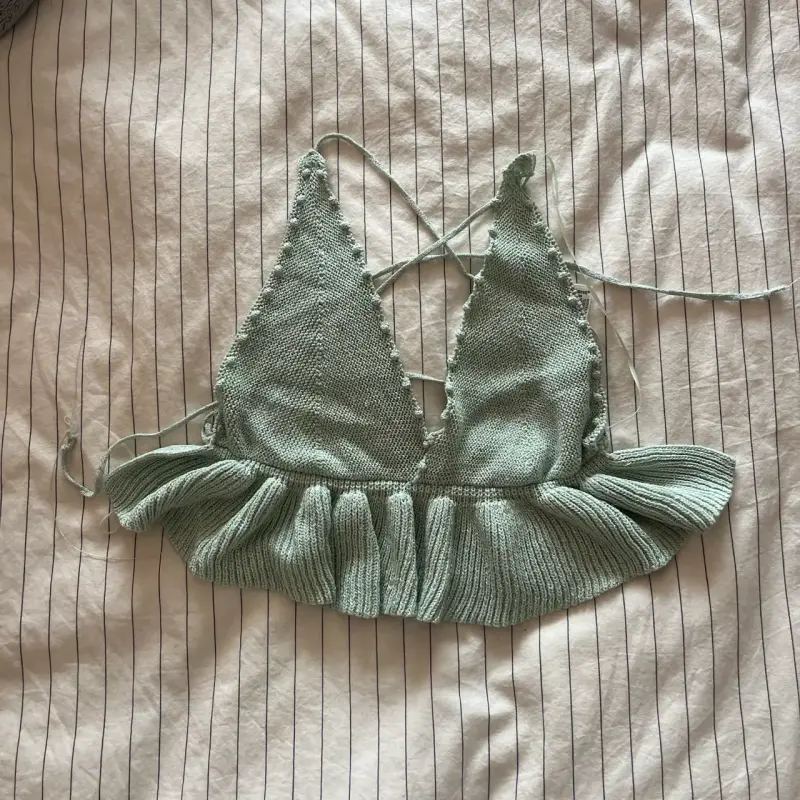 Top tejido verde con volantes y brillos